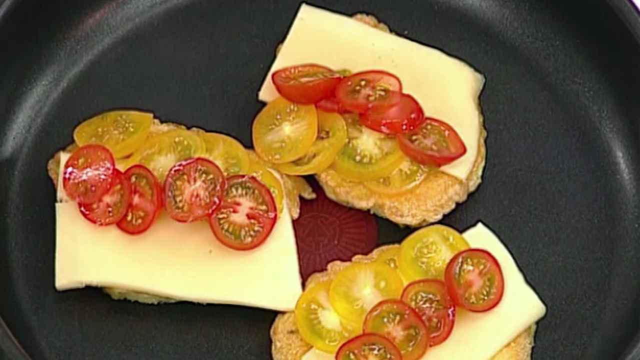 Желтые и красные помидоры черри нарезать тонкими кружочками, выложить их на тосты.
