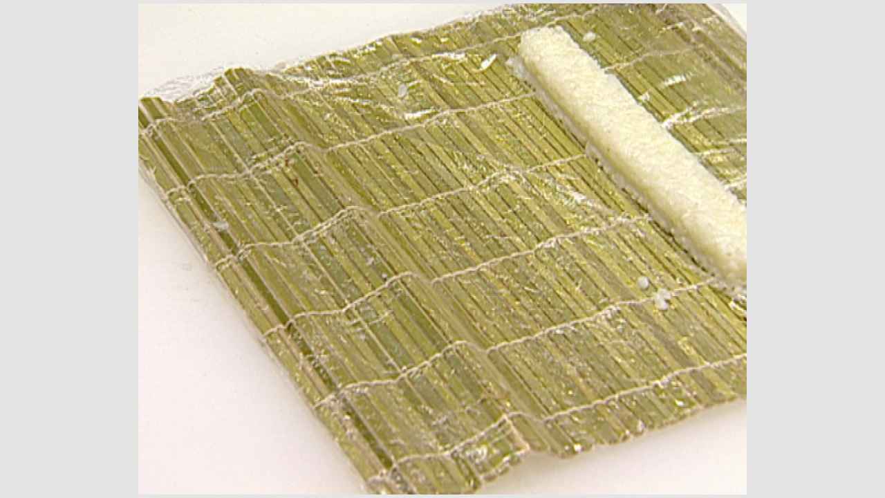 Предварительно отваренный рис свернуть роллом с помощью бамбукового коврика, выложить на тарелку.