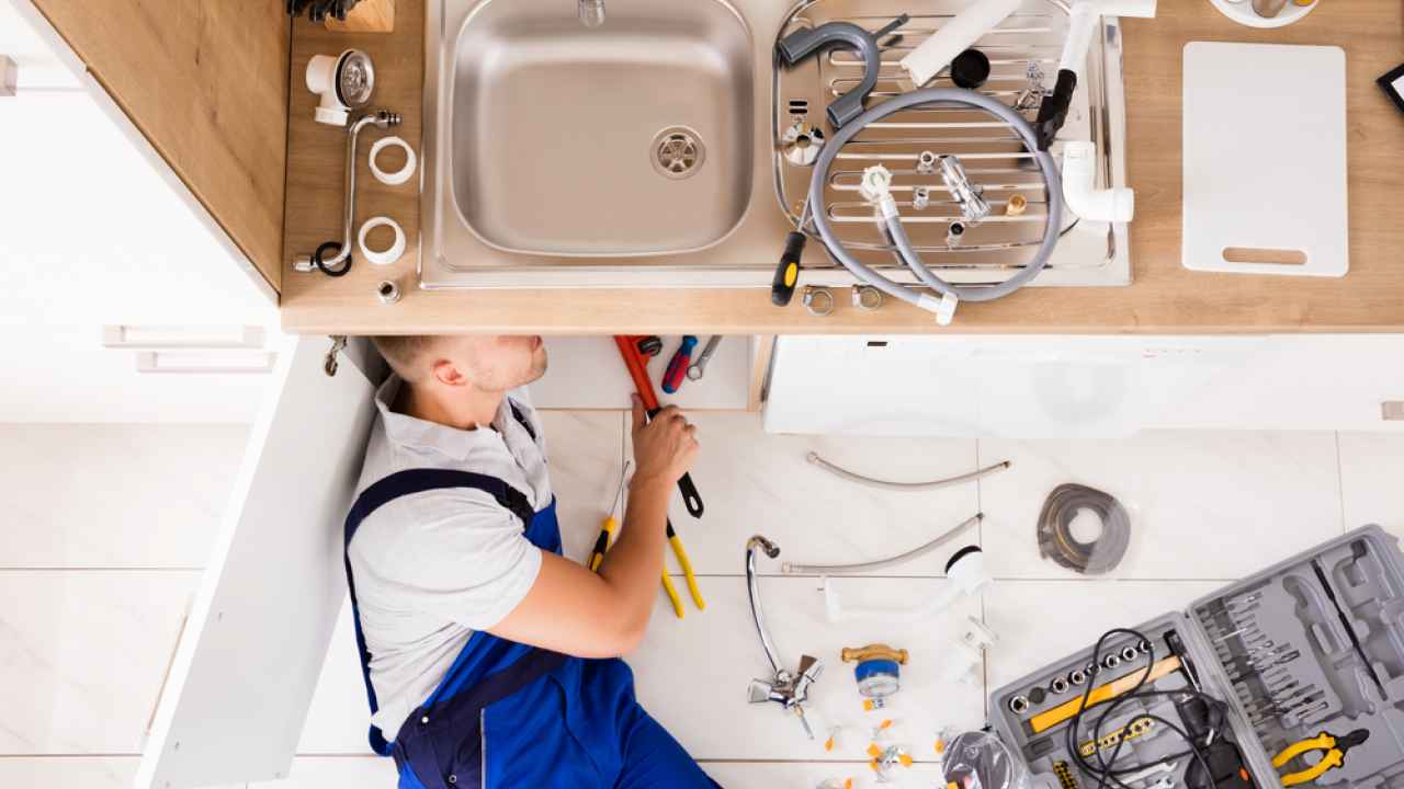 Close-up of hands adjusting a boiler system with precise instrumentation, showing maintenance work.